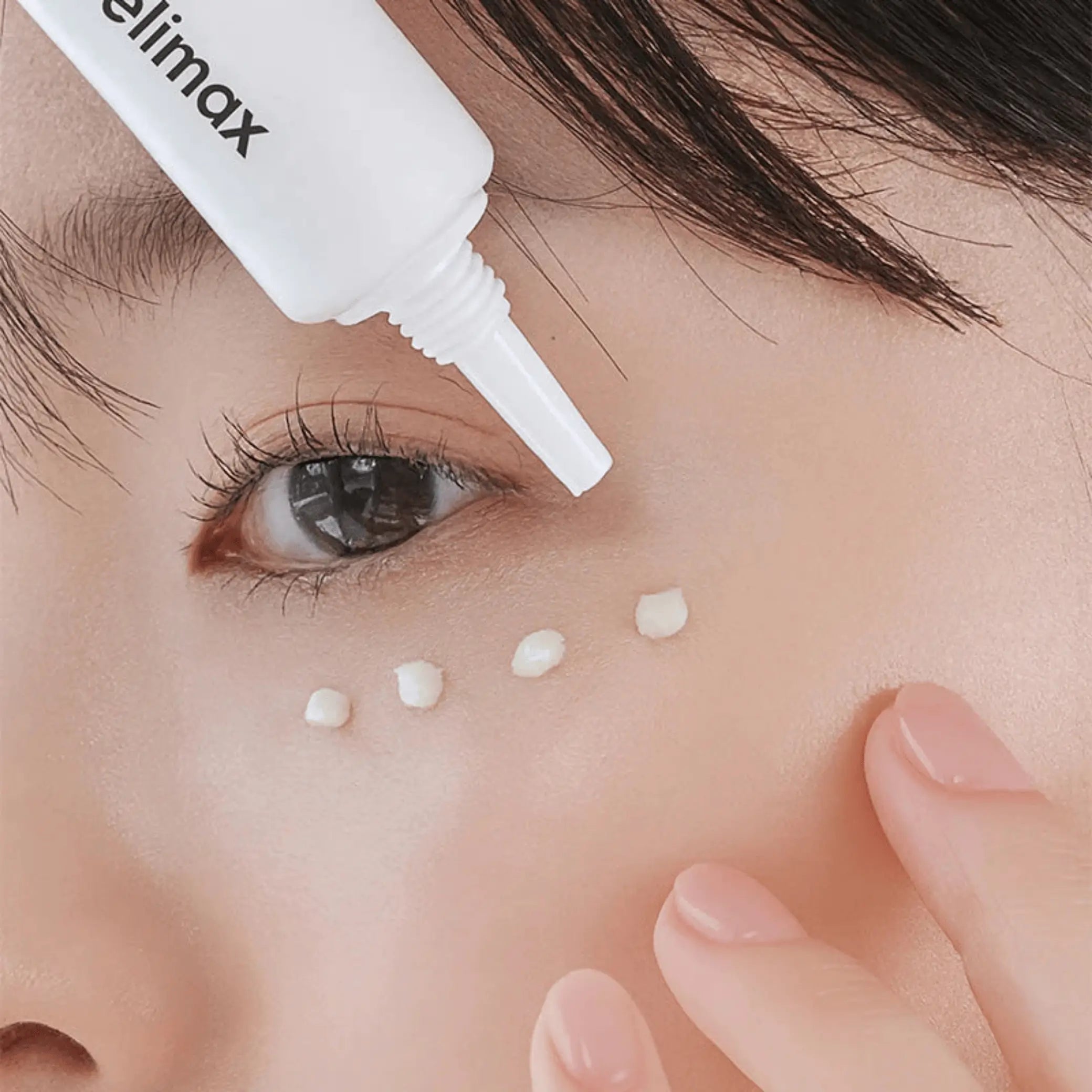 The Real Noni Ultimate Eye Cream da Celimax aplicado no contorno dos olhos em pequenos pontos