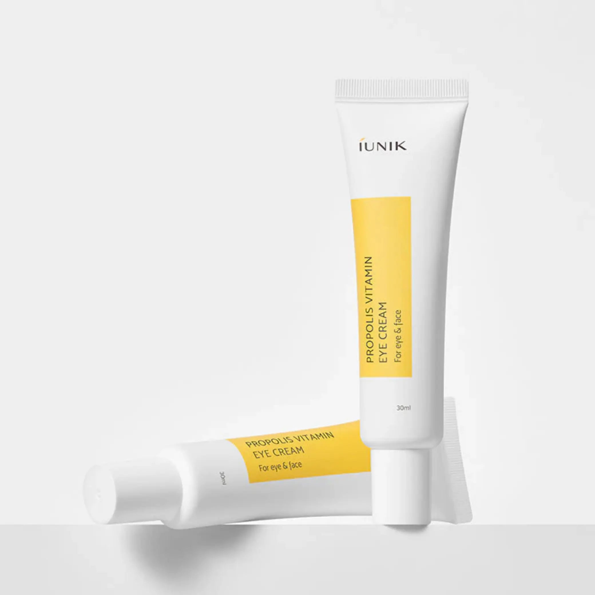 Propolis Vitamin Eye Cream da iUNIK dois tubos um em pé e outro deitado em fundo branco